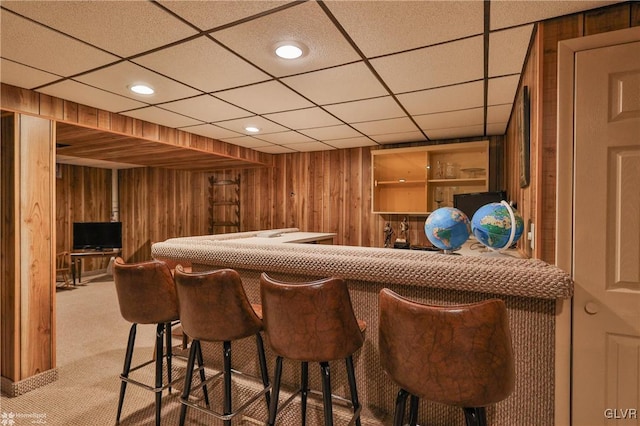 bar featuring indoor wet bar, recessed lighting, light colored carpet, and wood walls