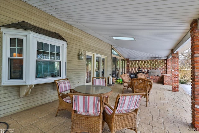 view of patio / terrace featuring outdoor dining space, an outdoor kitchen, and a grill