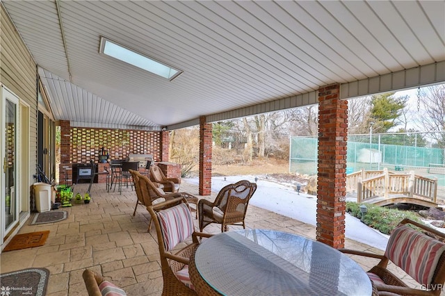 view of patio with outdoor dining area, an outdoor kitchen, and fence