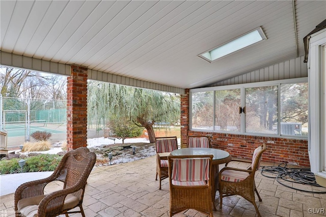 sunroom with vaulted ceiling with skylight