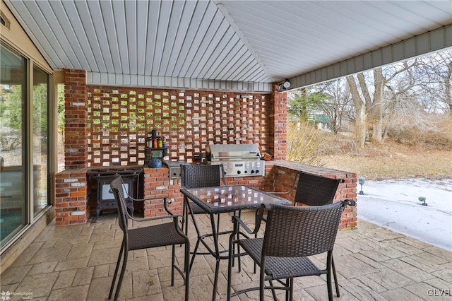 view of patio with exterior kitchen, outdoor dining area, area for grilling, and visible vents