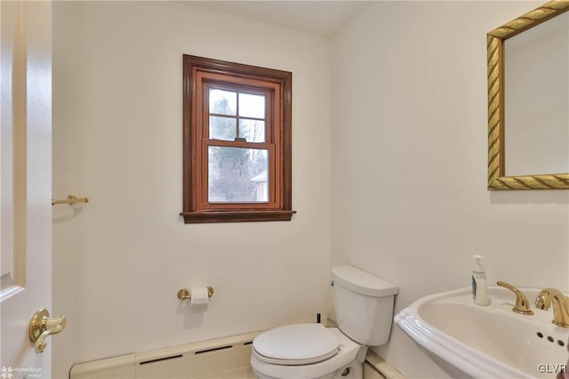 bathroom with toilet, baseboard heating, and a sink