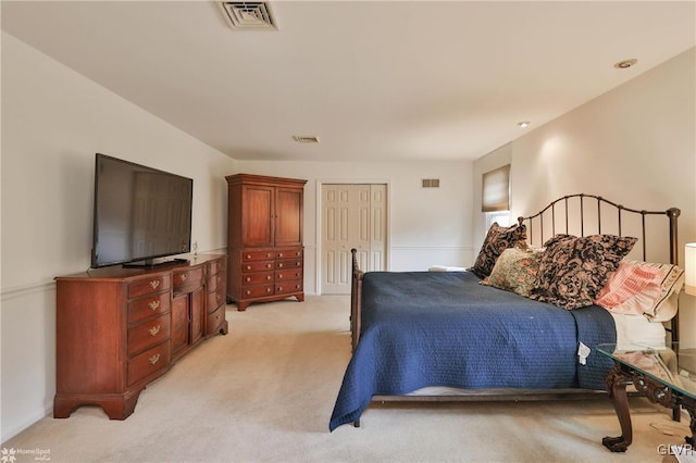 bedroom featuring light carpet, visible vents, and a closet