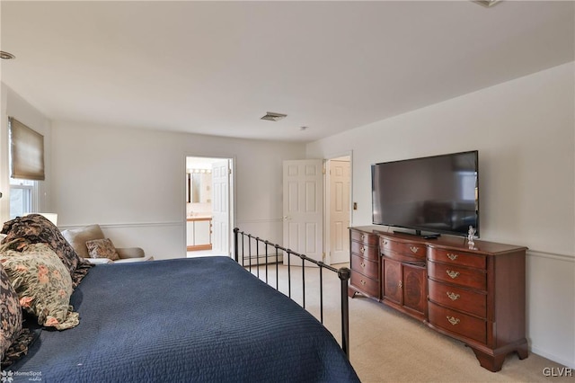 bedroom featuring light carpet, visible vents, and ensuite bathroom