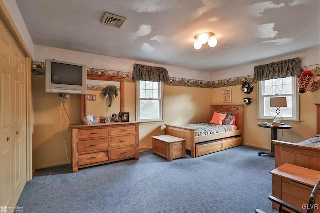 bedroom with dark colored carpet, visible vents, and baseboards