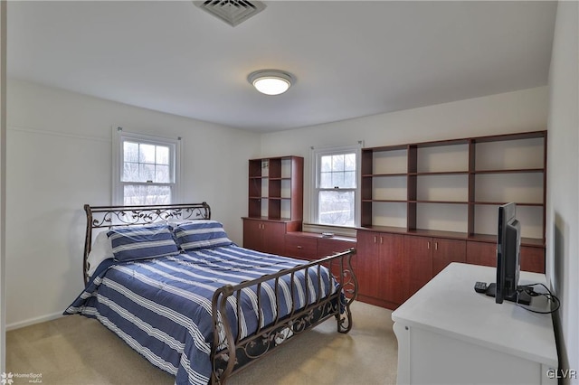 bedroom with baseboards, visible vents, and light colored carpet