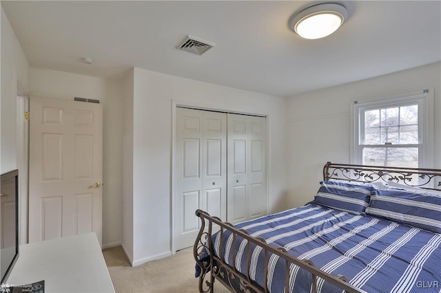 bedroom featuring a closet, light carpet, visible vents, and baseboards