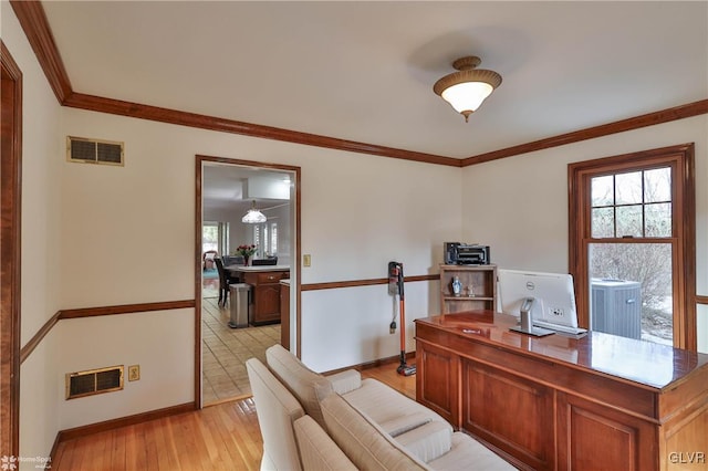 home office with visible vents, crown molding, light wood-style flooring, and baseboards