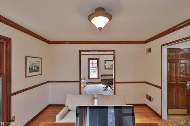 dining room with light wood-style floors, visible vents, ornamental molding, and baseboards