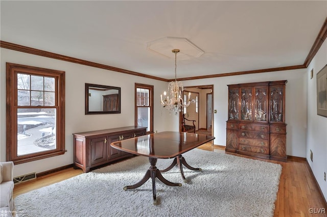 dining area featuring light wood-style floors, baseboards, visible vents, and ornamental molding