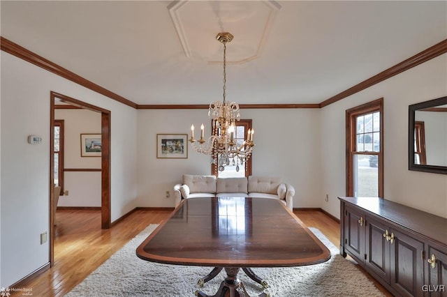 dining space with a chandelier, baseboards, crown molding, and light wood finished floors