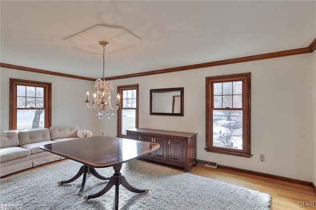 unfurnished dining area featuring light wood-style flooring, visible vents, baseboards, and ornamental molding