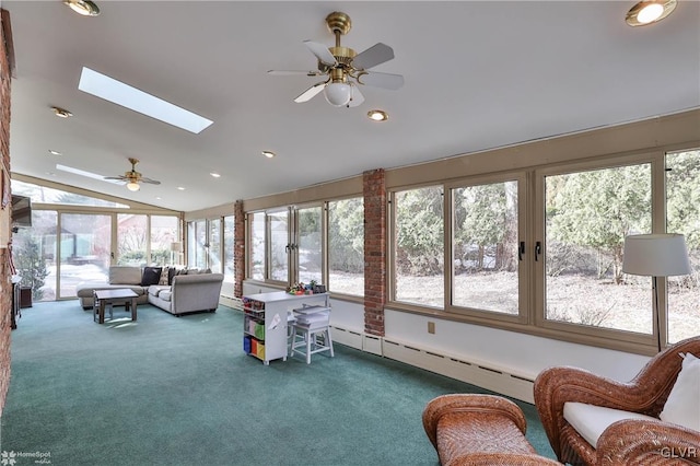 sunroom / solarium featuring a ceiling fan, vaulted ceiling with skylight, and baseboard heating