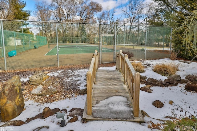 view of tennis court featuring a gate and fence