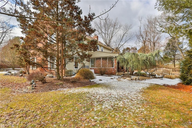 view of side of home with a chimney and brick siding