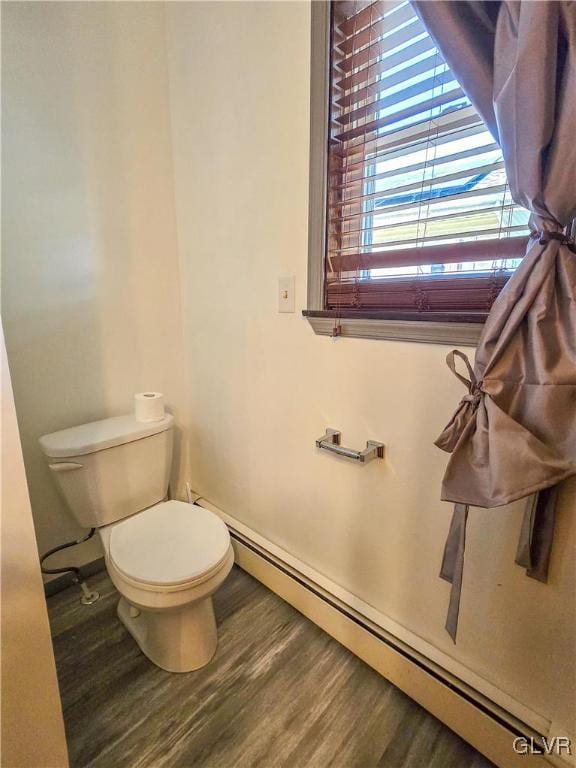 bathroom featuring toilet, baseboard heating, and wood finished floors