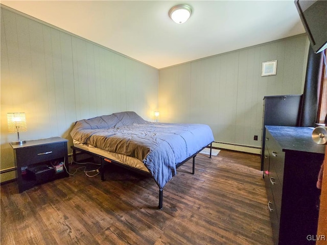 bedroom with baseboard heating and dark wood finished floors