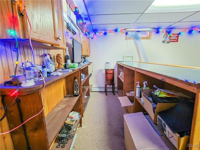 interior space with a baseboard heating unit and a drop ceiling