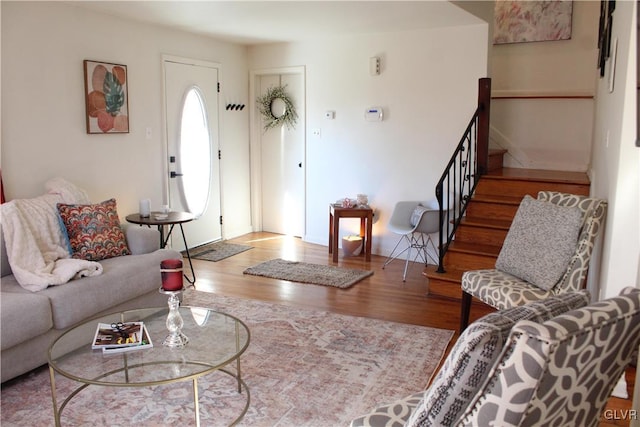 living area with stairway and wood finished floors