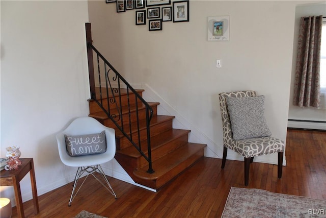 stairs with baseboards, baseboard heating, and wood finished floors