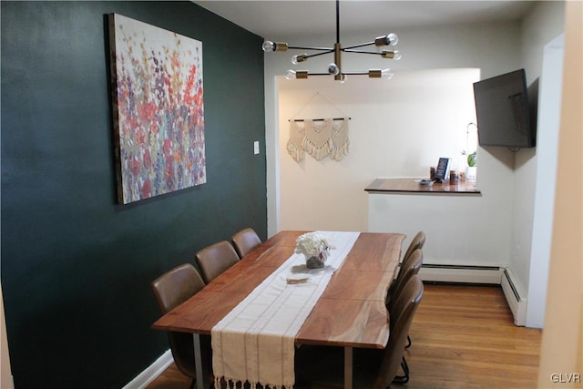 dining area featuring a chandelier, light wood-style flooring, and baseboards