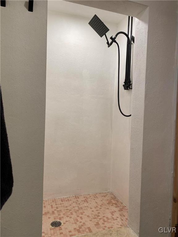 full bathroom with a stall shower and a textured wall