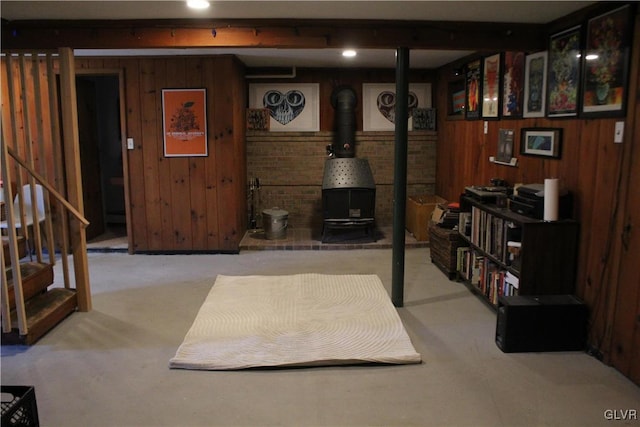 finished basement featuring light colored carpet, wood walls, and stairs