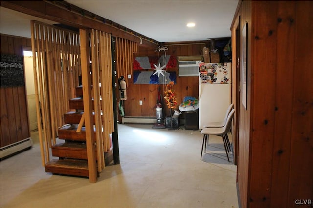 interior space with wood walls, baseboard heating, and a wall mounted air conditioner