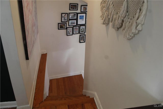 stairway featuring wood finished floors and baseboards