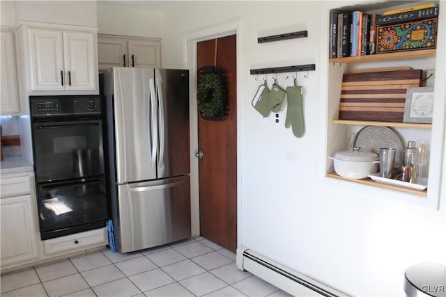 kitchen with a baseboard radiator, dobule oven black, white cabinetry, light countertops, and freestanding refrigerator