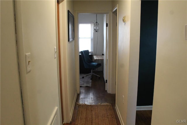 hall with dark wood-type flooring and baseboards