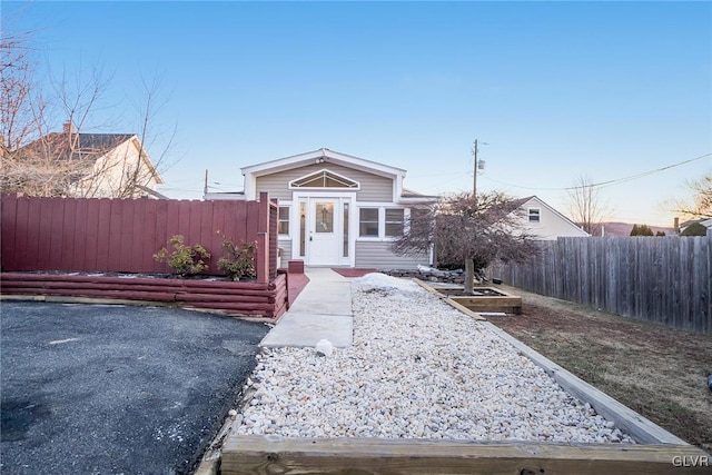 view of front facade featuring fence private yard and a garden