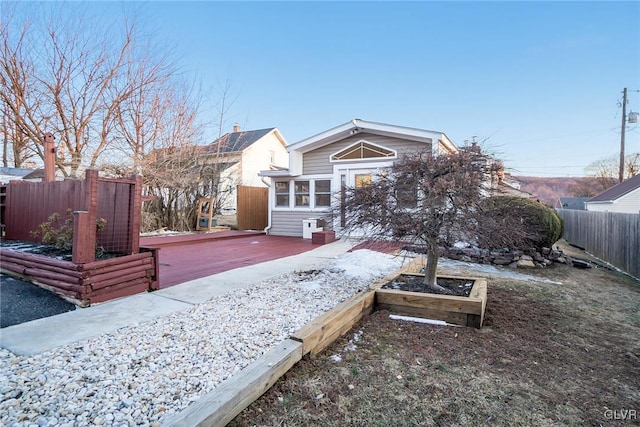 view of front of home featuring fence and a wooden deck