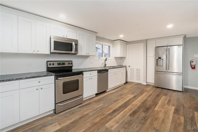 kitchen featuring stainless steel appliances, recessed lighting, white cabinetry, and dark wood finished floors