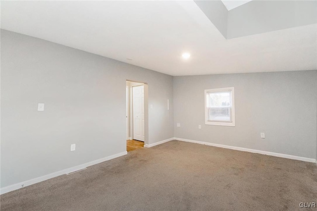 spare room with baseboards and light colored carpet