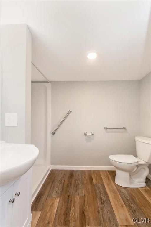 bathroom featuring vanity, wood finished floors, toilet, and baseboards