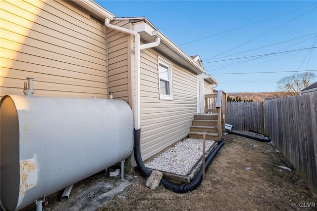 view of side of home featuring a fenced backyard and heating fuel