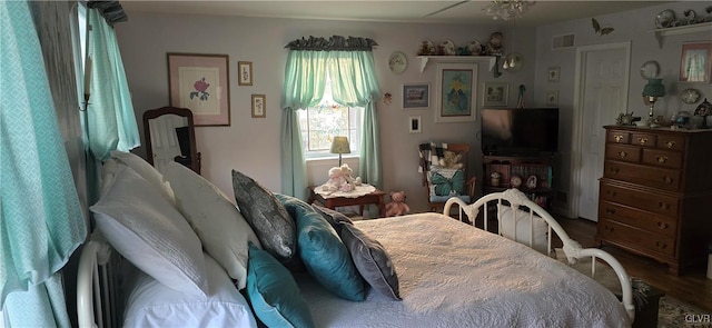 bedroom with visible vents and wood finished floors