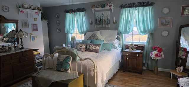 bedroom with baseboards and wood finished floors