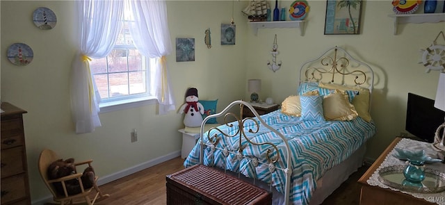 bedroom with wood finished floors and baseboards