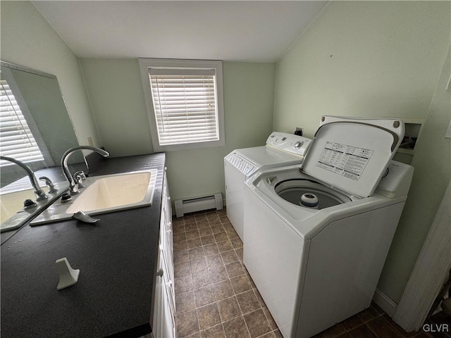 clothes washing area with baseboards, washer and clothes dryer, baseboard heating, laundry area, and a sink