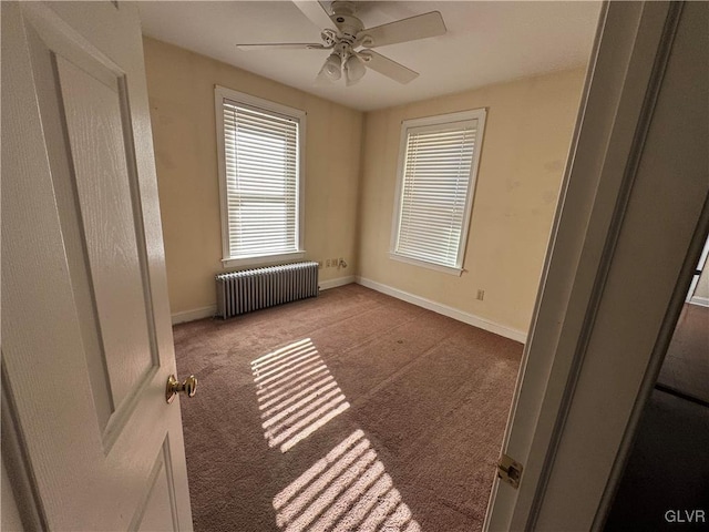 unfurnished room featuring carpet flooring, radiator heating unit, a ceiling fan, and baseboards