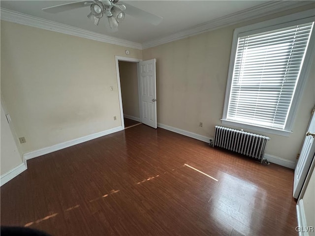 spare room featuring wood finished floors, radiator, ceiling fan, and ornamental molding