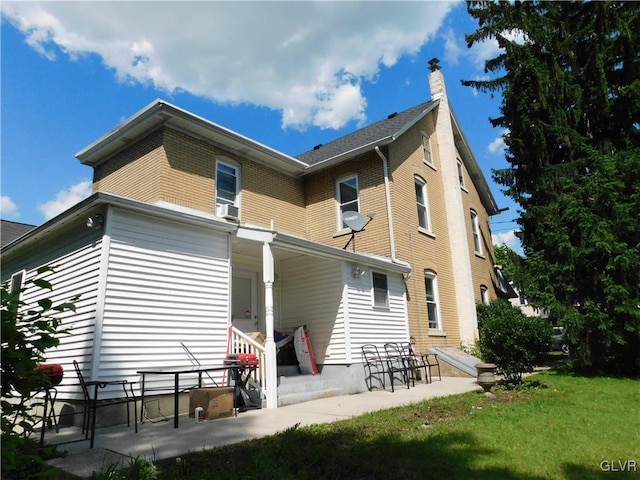 back of house featuring a yard and a chimney