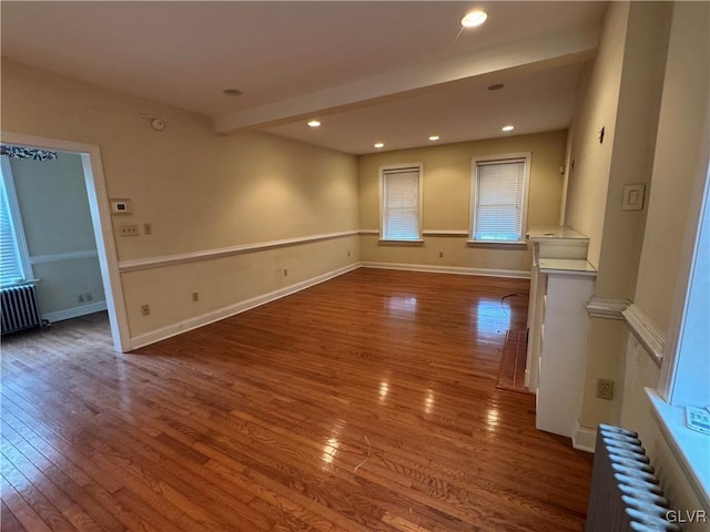 empty room featuring recessed lighting, radiator, baseboards, and hardwood / wood-style flooring