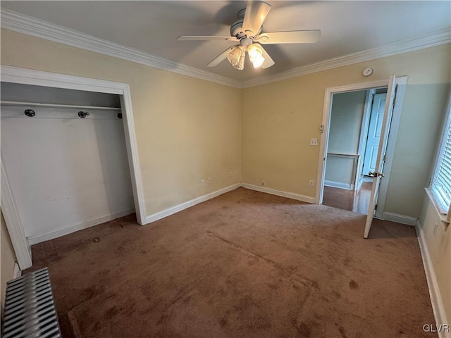 unfurnished bedroom with ceiling fan, baseboards, carpet floors, and ornamental molding