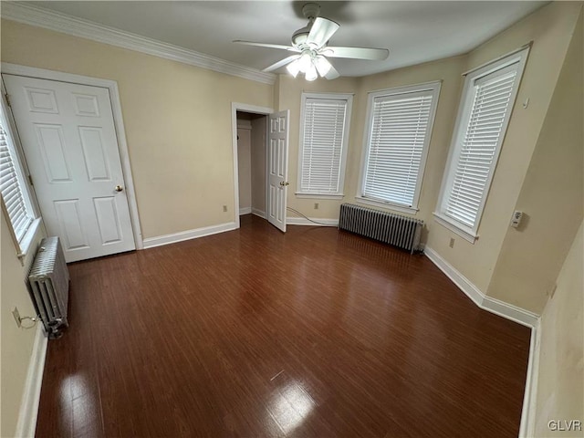 unfurnished bedroom with baseboards, wood finished floors, and radiator heating unit