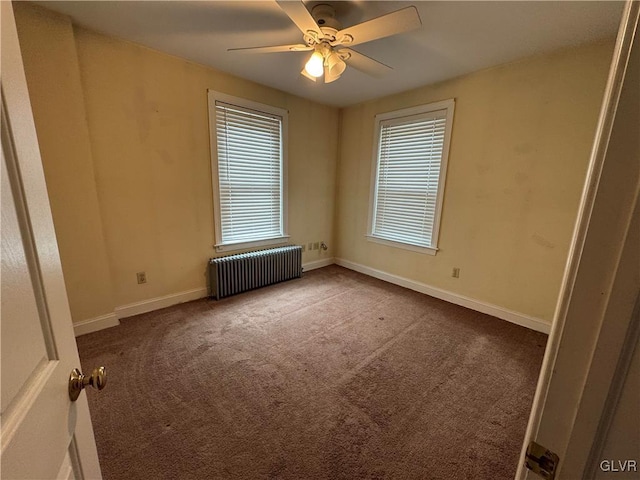 spare room featuring baseboards, radiator heating unit, carpet, and a ceiling fan