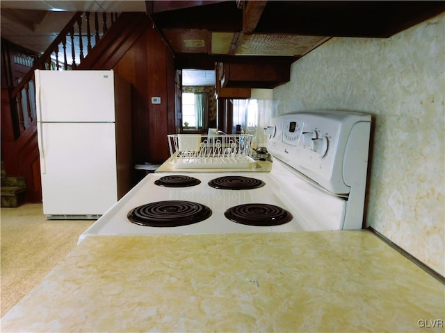 kitchen with white appliances and carpet floors