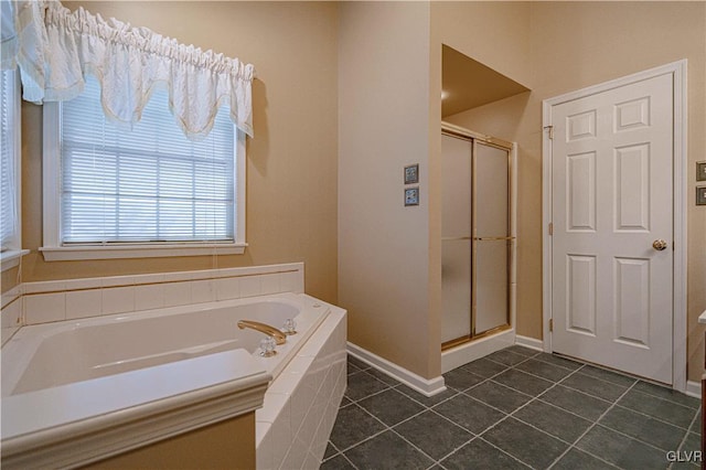 bathroom featuring tile patterned flooring, a garden tub, a shower stall, and baseboards